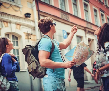Mann steht in einer Stadt und hält eine Stadtkarte in der Hand