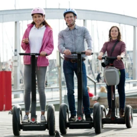 Drei Personen fahren Segway durch eine Stadt