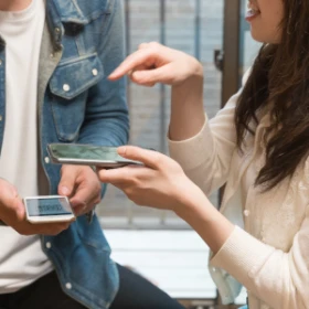 zwei Personen tauschen QR-Codes aus