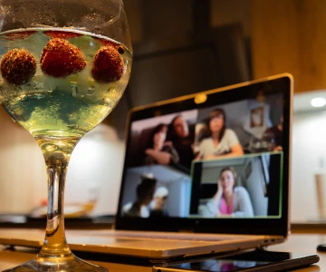 Gin Cocktail vor einem Meeting auf einem Laptop