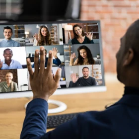 Mann begrüßt die Gruppe im Meeting freundlich