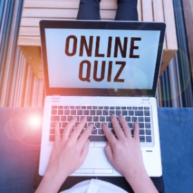 Man sitzt vor seinem Laptop aufdem Online Quiz steht
