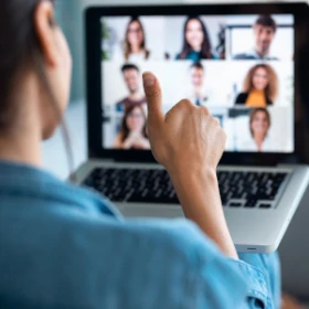 Man sitzt vor seinem Laptop und zeigt seinen Daumen nach oben