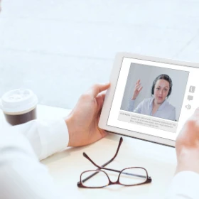 Person nimmt an einem Meeting über sein Tablet teil