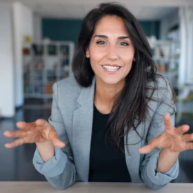 Frau erklärt Coaching Teilnehmern etwas