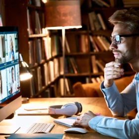 ein Mann sitzt vor seinem Computer und hört interessiert zu
