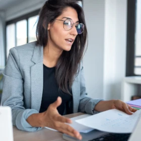 Frau erklärt den Teilnehmer über den Laptop etwas