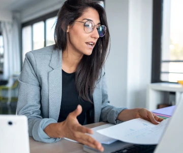 Frau erklärt den Teilnehmer über den Laptop etwas