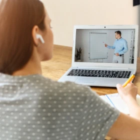 Frau schreibt sich Stichpunkte des Seminars auf