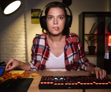 Frau sitzt nervös und gespannt vor ihrem Rechner