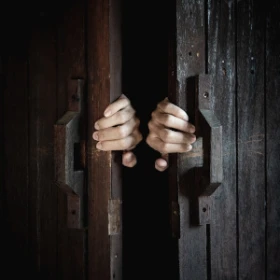 2 Hände umfassen eine große Tür die langsam auf geht