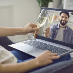 Personen stoßen virtuell über ein Meeting mit einem Sekt an