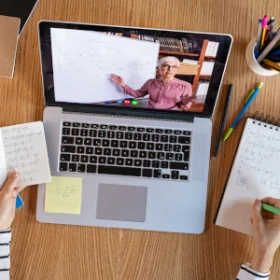 Person schreibt während eines Seminars Notizen auf