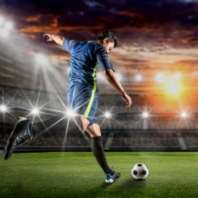 Person holt aus und möchte den Fußball treffen