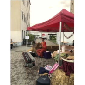 Marktstand unter rotem Zelt, Musiker spiel Gitarre, Strohballen, mittelalterliche Dekoration