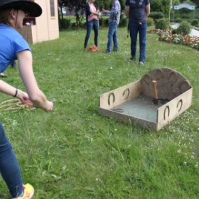 Person wirft Hufeisen beim Hufeisenwerfen