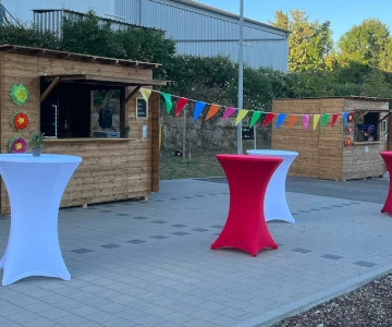 EVINTA_Firmen_Sommermarkt_Bild01 kleine Holzhütten mit Stehtischen davor