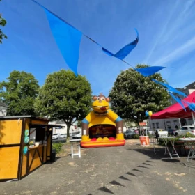 geschmückte Markthütte, Hüpfburg für Kinder, Wimpelkette bunt, roter Pavillon