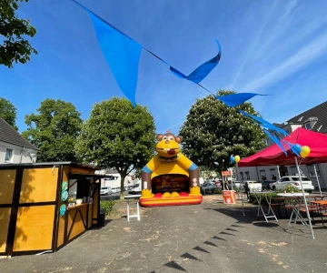 geschmückte Markthütte, Hüpfburg für Kinder, Wimpelkette bunt, roter Pavillon