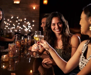 EVINTA_Bollywood Weihnachtsfeier_Bild01 zwei Frauen stoßen mit Wein an