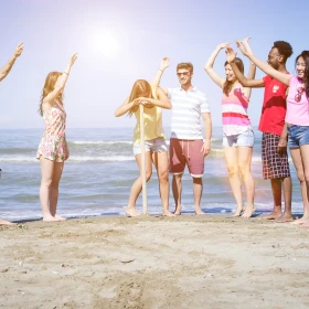 Gruppe von Menschen am Strand jubelt