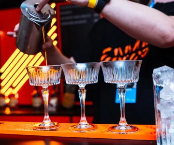 Cocktailgläser auf Theke werden befüllt