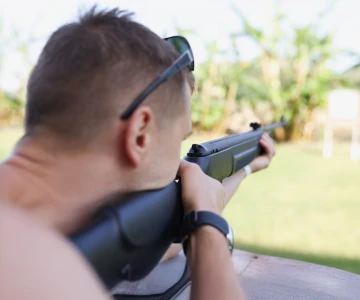 Man liegt auf einer Plattform und hat ein Lasergewehr in der Hand