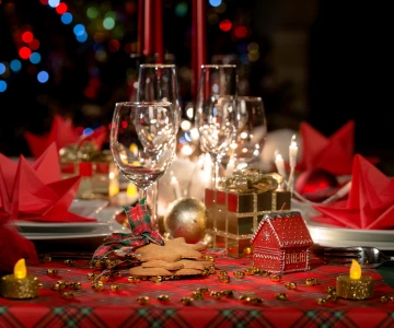 Weihnachtlich geschmückter Tisch mit Kerzen und roten Dekoelementen