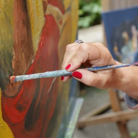 Person malt ein Bild auf einer Leinwand