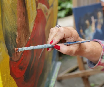 Person malt ein Bild auf einer Leinwand