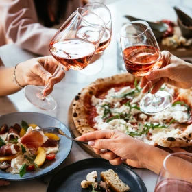 Essen beim Italiener, anstoßen mit Aperol, Pizza, Pasta