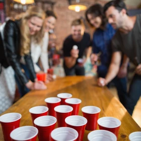 Personen versuchen einen Ball in ein Becher zu werfen