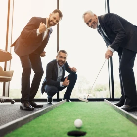 EVINTA_Bürogolf_Bild03 Gruppe von Männer beim Einlochen