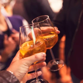 Zwei Personen stoßen mit Aperol an