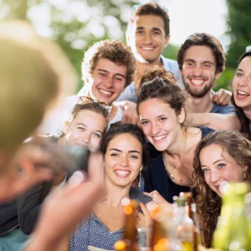 Gruppe macht ein Gruppenfoto, alle Personen lachen in die Kamera