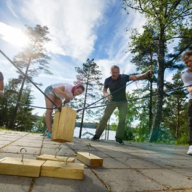 Personen versuchen Holzblöcke an ein Seil zu hängen