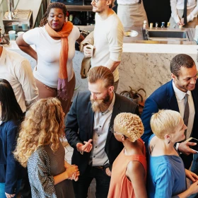 Gruppe von Menschen in der Pause einer Tagung stehen in kleinen Gruppen und reden miteinander