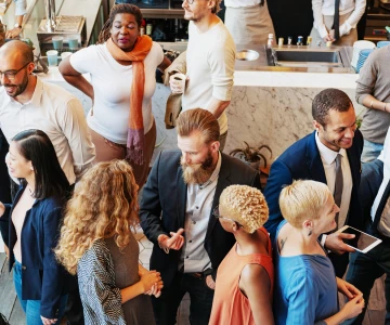 Gruppe von Menschen in der Pause einer Tagung stehen in kleinen Gruppen und reden miteinander