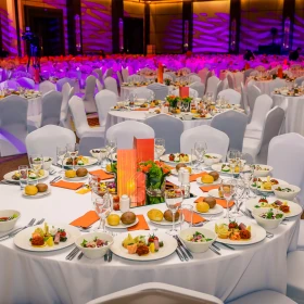 festlich dekorierter runder Tisch mit Weißen Tischdecken und weißen Stuhlhussen, Essen wurde eingesetzt