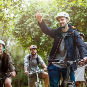 Zwischenstop bei einer geführten Fahrradtour, Guide erklärt etwas und zeigt auf etwas