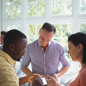 3 Personen schauen gemeinsam auf ein Handy