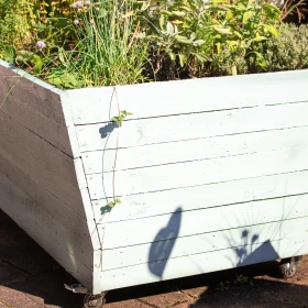 Hochbeet aus Holz weiß gestrichen mit Kräutern bepflanzt