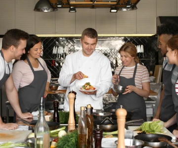 Koch erklärt ein Gericht bei einem Kochkurs
