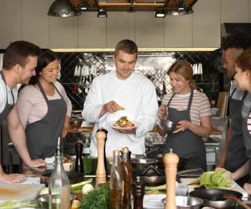 Koch erklärt ein Gericht bei einem Kochkurs