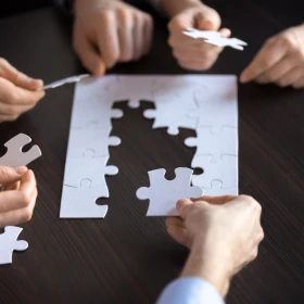 Personen legen gemeinsam ein Puzzle