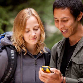 zwei Personen schauen auf ein Geocaching Gerät