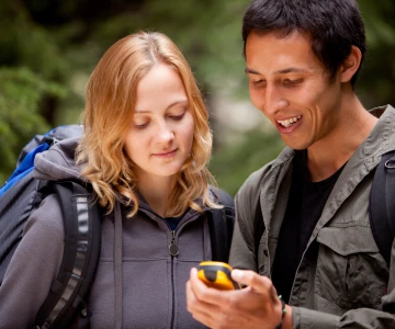 zwei Personen schauen auf ein Geocaching Gerät