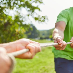 zwei Personen ziehen an einem Seil beim Tauziehen