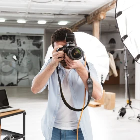 Fotograf fotografiert mit einer professionellen Kamera in einem Studio
