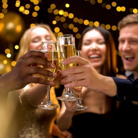 Menschen stoßen mit Sekt an und freuen sich